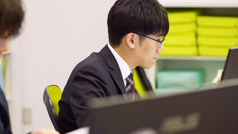 デスクで作業をする男性の写真